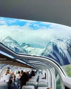 Train car window with view of mountains