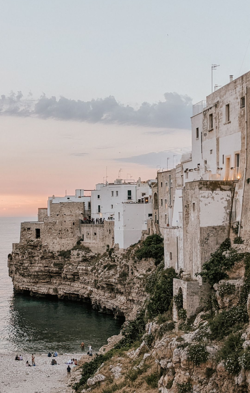 Stunning sunset over a beautiful coastal town in Italy, highlighting the picturesque scenery that a travel agent can help you explore