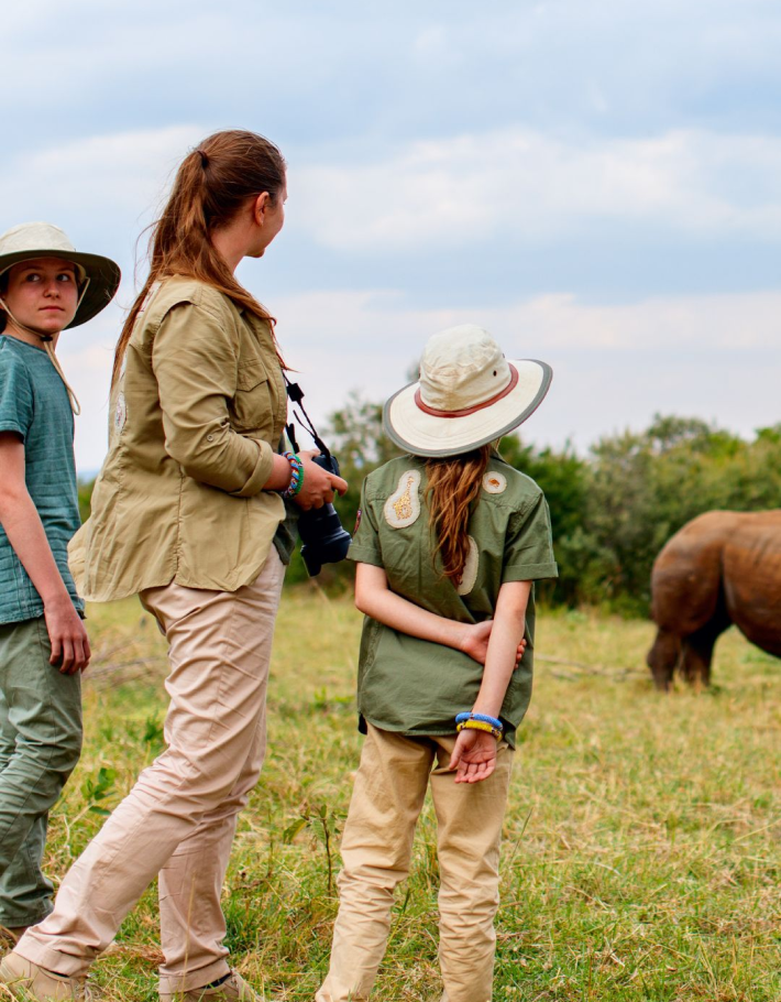 Family with young children observing African wildlife alongside their tour guide 