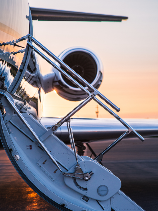 Semi-private or private jet at sunset with loading stairs down, ready for your arrival